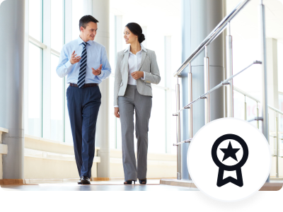 Two business colleagues walking in corridor of modern building